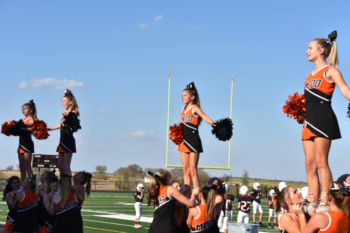 Cheer away. 7 and 8 grade students doing a cheer routine at a weekly middle school home game. That night Aledo took the win with the support of our cheerleaders.  That night was a successful game, we had so much fun cheering! says Holland Fay. 