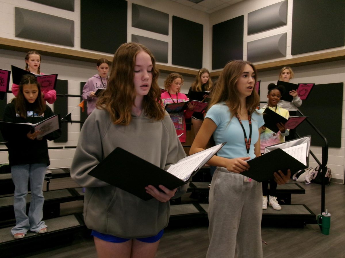 Two 8th graders, Callee Lasher, Choir President and London Sustala, Choir Vice President practice singing their songs for their Fall Concert. 